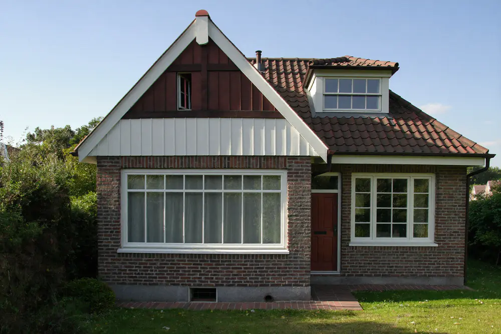 Dertiger jaren woning met een steil pannendak en een houten dakkapel met zadeldakje