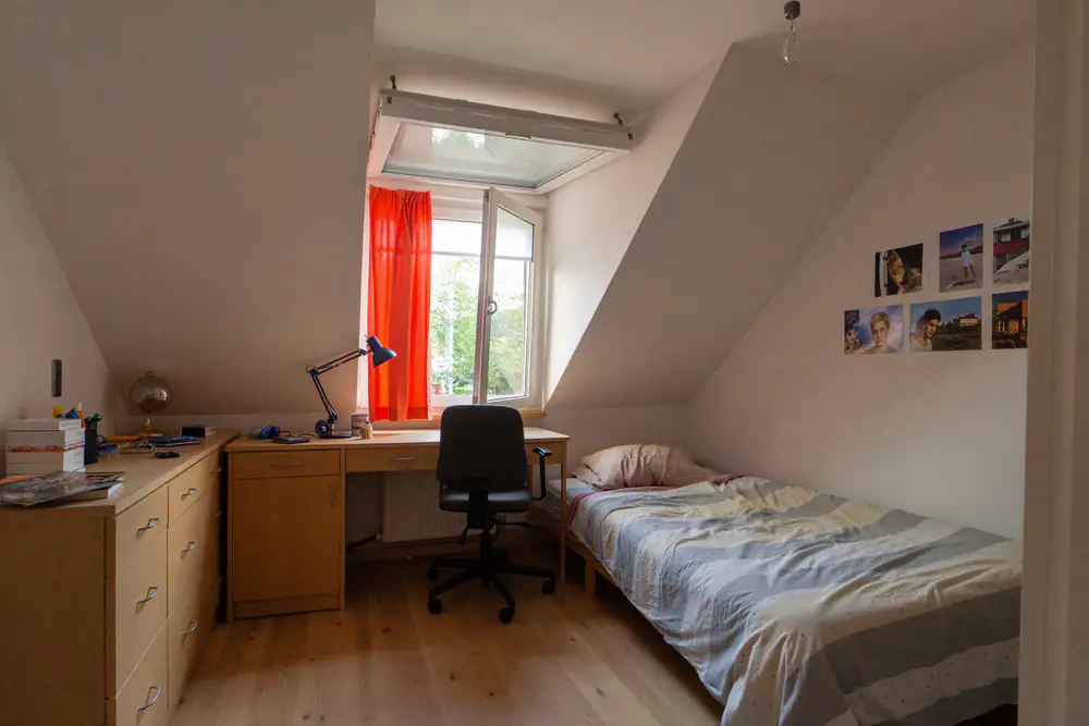 Gezellige zolderslaapkamer met een bureau onder het dakkapelraam